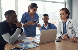 A nurse consults with her colleagues in a hospital meeting room